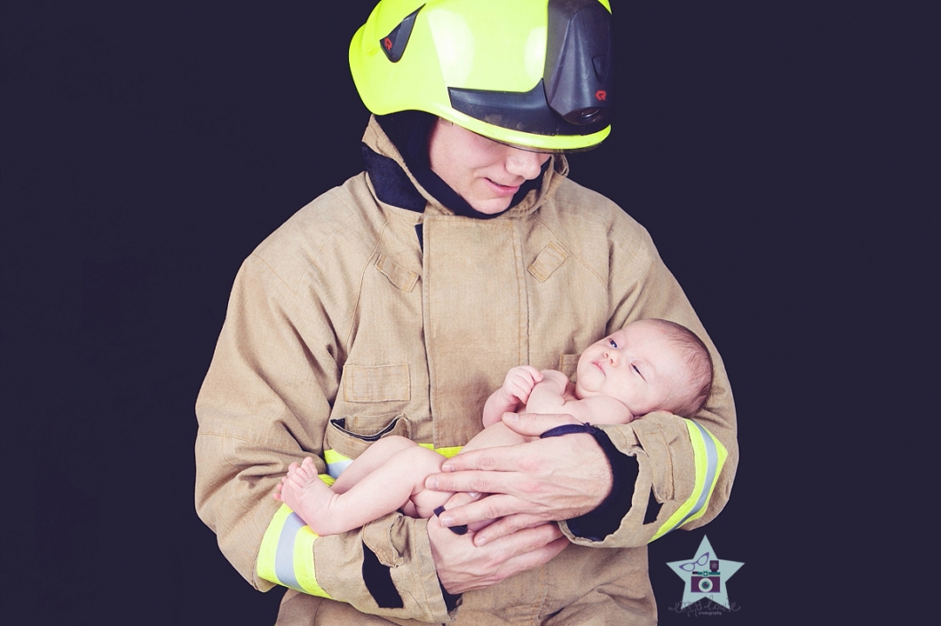 portrait of fireman cradling baby daughter - Baby photography Edenbridge