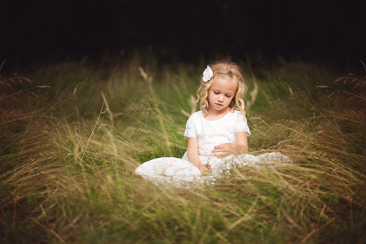Girl sitting in the long grass - child portrait photography kent