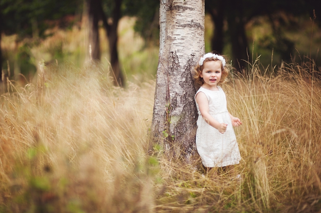 Pretty little girl in white dress standing by tree - child portrait photography Tunbridge Wells